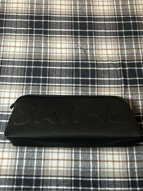SKIMS neoprene cosmetic pouch with embossed logo.